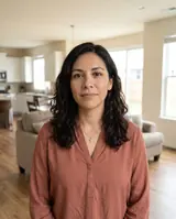 Sofia, a fictional buyer standing in a bright open-plan home, facing the camera.